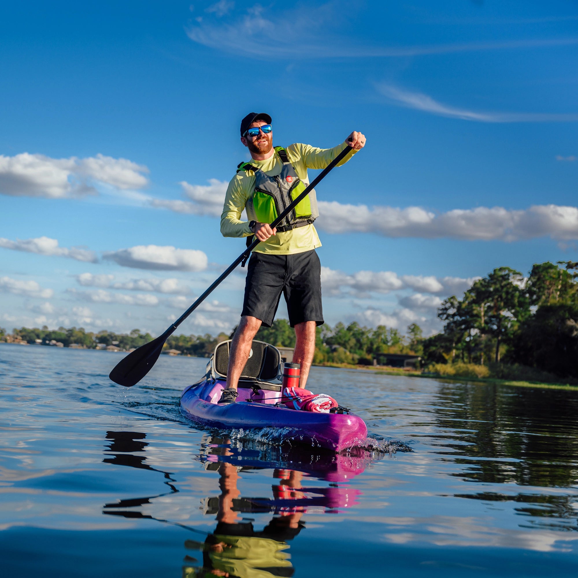 Man standing on a touring kayak during an outdoor paddling adventure on open water